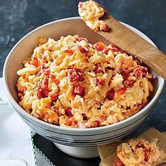 a bowl filled with macaroni and cheese on top of a table next to crackers