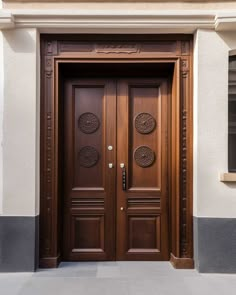 two wooden doors on the side of a building