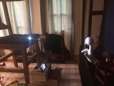 a living room filled with lots of furniture and books on top of a floor next to a window