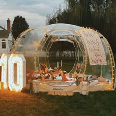 an inflatable tent is set up on the grass with lights around it and a sign that reads 10