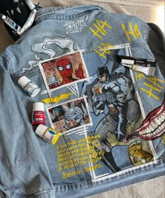 the back of a jean jacket with pictures on it and various other items scattered about