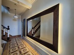 This extra-large wall mirror will suite either contemporary or traditional interior styles. The grand frame made in cherry and finished in dark oak stain oversized mirror is certainly a real showstopper. With engraved Greek key pattern, it gives this mirror an awe - inspiring finish. The rectangular frame dresses the wall, adding elegance and a sense of spaciousness Cleverly incorporated led lights add a warm and cosy glow to the frame and the hallway. Hanging Big Mirrors On The Wall, Big Mirror Entryway, Massive Mirror, Mirror Behind Nightstand, Oversized Wall Mirror, Extra Large Wall Mirrors, Extra Large Mirror, Lights Around Mirror, Extra Large Mirrors