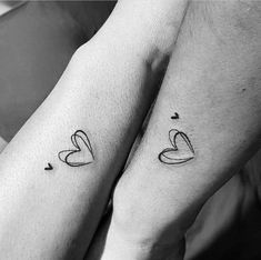 two people holding hands with tattoos on their arms and the words love are written in black ink