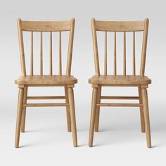 two wooden chairs sitting next to each other