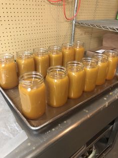 several jars filled with liquid sitting on top of a metal tray