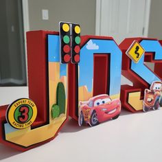 the letters are made out of cardboard and have cars on them