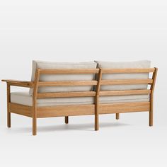 two wooden couches sitting next to each other