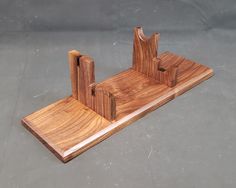 a wooden stand with two pieces of wood sticking out of it's sides on a gray surface