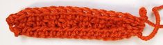 an orange crochet stitch on a white surface