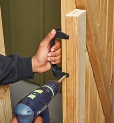 a person using a drill to attach a piece of wood