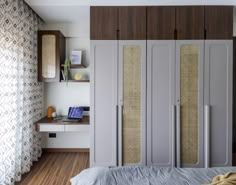 a bedroom with a bed, desk and closets in the wall next to it