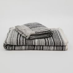 two black and white striped blankets folded on top of each other, one with fringes