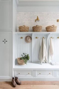 a coat rack with baskets and hats on it in a white entryway, next to shoes