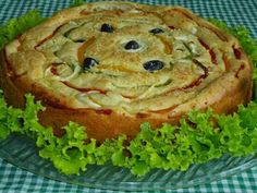 a cake on a plate with lettuce and blueberries in the center, sitting on a checkered table cloth