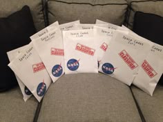 several envelopes sitting on top of a couch with nasa stickers all over them