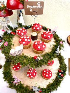 cupcakes are arranged in the shape of a heart on top of a table