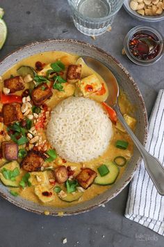 a bowl filled with rice, meat and veggies on top of a table