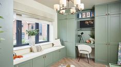 a room with green cabinets and a window seat