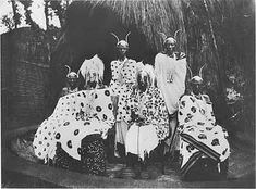 an old black and white photo of some people dressed in animal print outfits with hats on