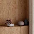 three vases are sitting on a shelf in front of a wall with wood paneling