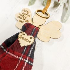 wooden angel ornament with personalized message on the front and back, attached to a red tartan bag