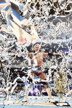 a man standing on top of a wrestling ring surrounded by confetti and streamers