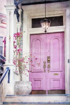 a pink front door with flowers on the steps