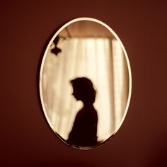 a person standing in front of a round mirror