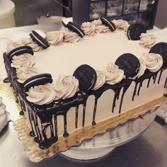 a cake with oreo cookies and white frosting on it sitting on a table