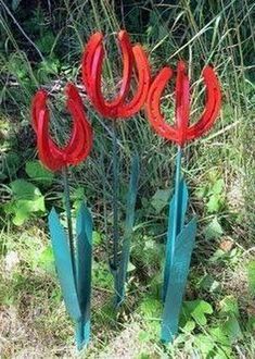 some red flowers are in the grass and there is a video playing on it's screen