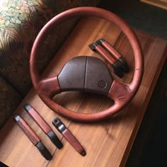 a wooden table topped with a steering wheel and other accessories