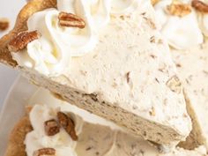 a piece of pie with whipped cream and pecans on top