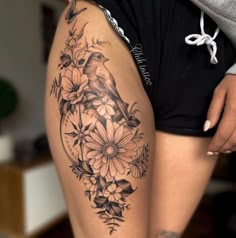 a woman's thigh with flowers and a bird on it