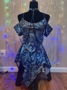 This item is final sale. Comes as a 4pc set of triangle top, fairy skirt, o-ring choker necklace with chains attached to upper arm sleeves. Comes with 3d printed blue dinosaur charm on hook. Size Large. Fits 37-39 inch bust, 32-34 waist and 41-43 hips. 4 way stretch nylon spandex fabric. Hand wash and hang dry. Dry off metal hardware after washing. Festival Asymmetrical Skirt, Rave Skirt Set, Rave Outfits Mermaid, Silver Rave Skirt, Disco Skirt, Fairy Kei Mini Skirt With Ruffles, Rave Ideas, Blue Dinosaur, Fairy Skirt