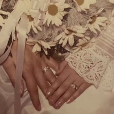 a woman's wedding ring and bouquet of sunflowers