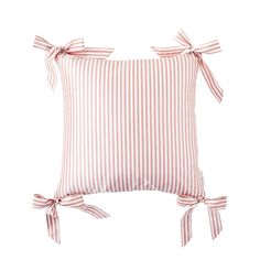 a pink and white striped pillow with bows on the front, tied to it's sides