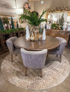 a dining room table with chairs and vases on the rug in front of it