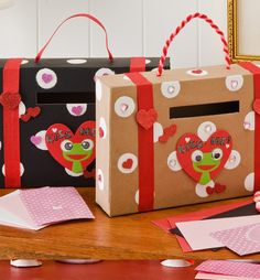 two boxes with hearts on them sitting on a table next to cards and envelopes