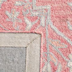 an area rug with various colors and designs on it, including pinks, greys, and blue