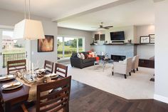 a living room and dining area with wood flooring in the middle, large open concept space