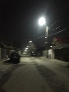 a car driving down a dark street at night