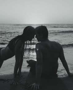 a man and woman kissing on the beach