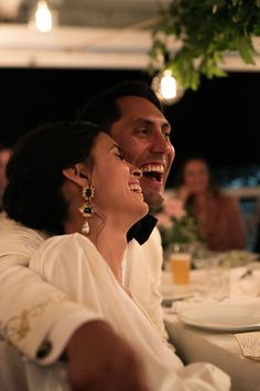 a man and woman sitting at a table laughing