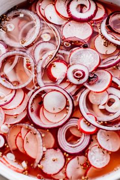 sliced red onions are in a pot with sauce