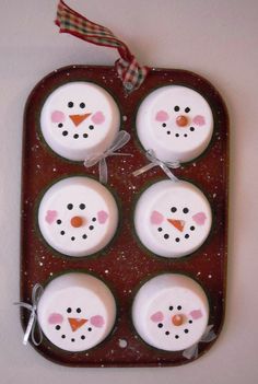 four snowman cupcakes sitting in a muffin pan