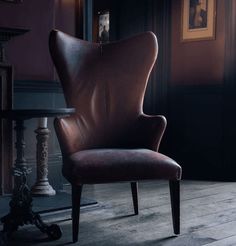 a brown leather chair sitting on top of a wooden floor