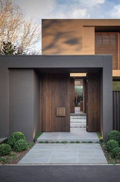 an entrance to a modern home with wooden doors