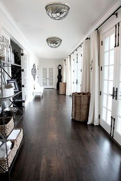 an image of a hallway with white walls and wood flooring on the right side