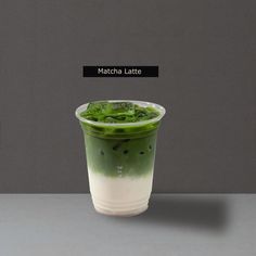 matcha latte with green and white toppings in a plastic cup on a table