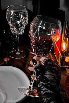 a person holding a wine glass in front of a table with plates and glasses on it